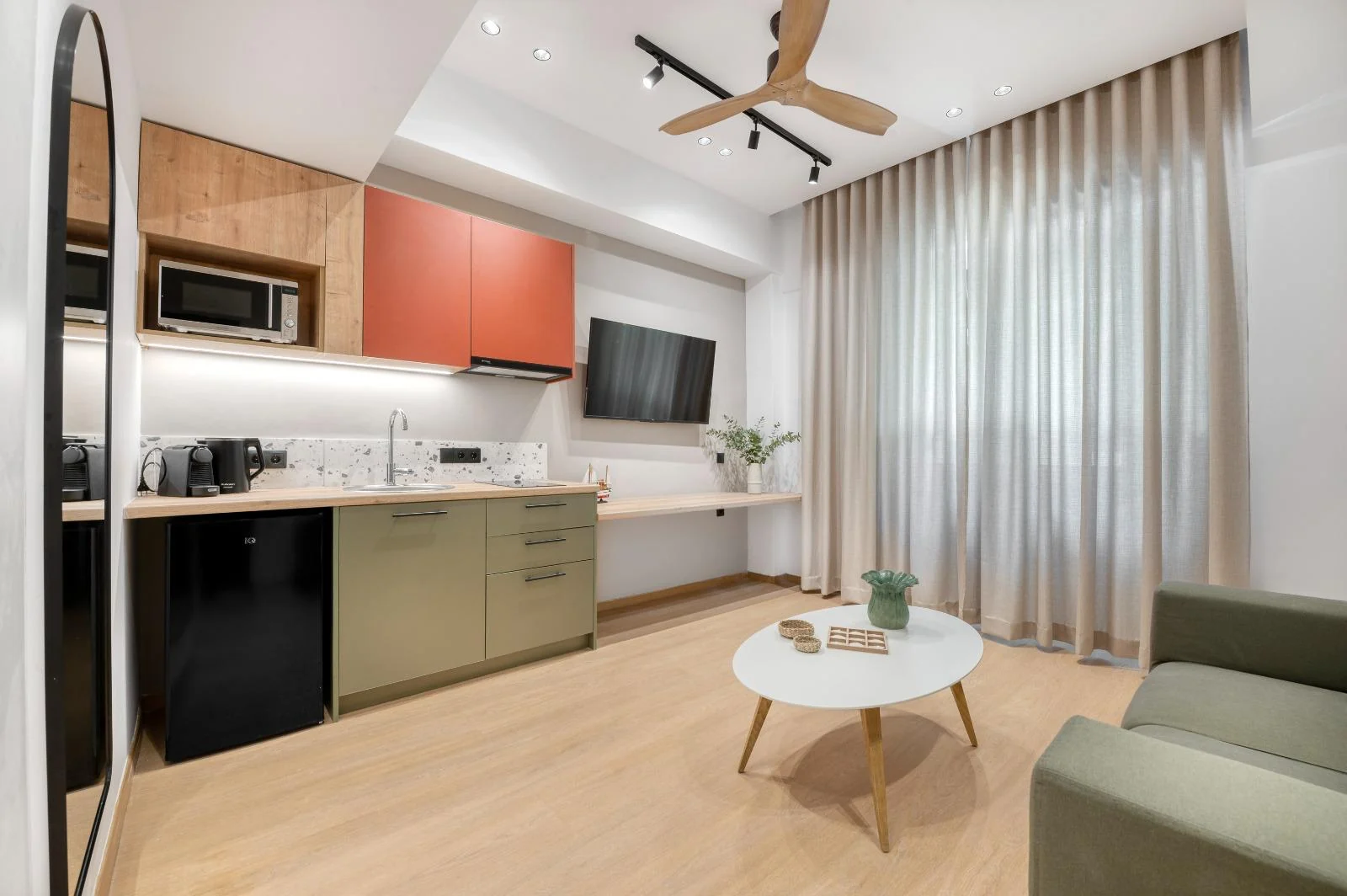 Green and terracotta kitchenette beside the living area at Dock 38