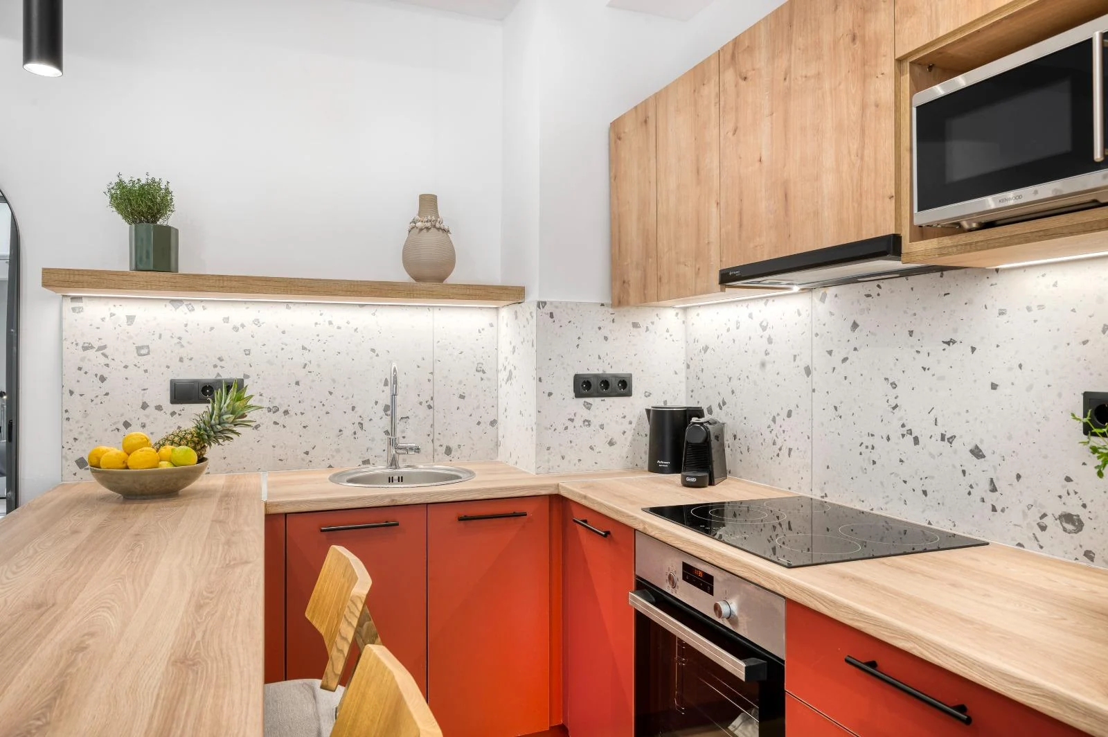 Terracotta kitchen with oven, cooktop and breakfast counter at Dock 38